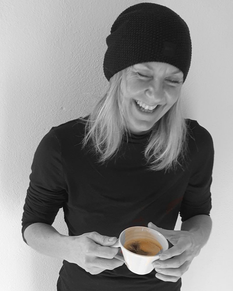 Alexandra Gauder laughing, holding a cup of coffee