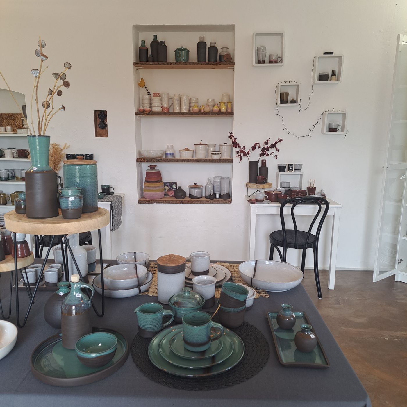 Showroom der Töpferei Tonikum mit Geschirr in Grün- und Blautönen